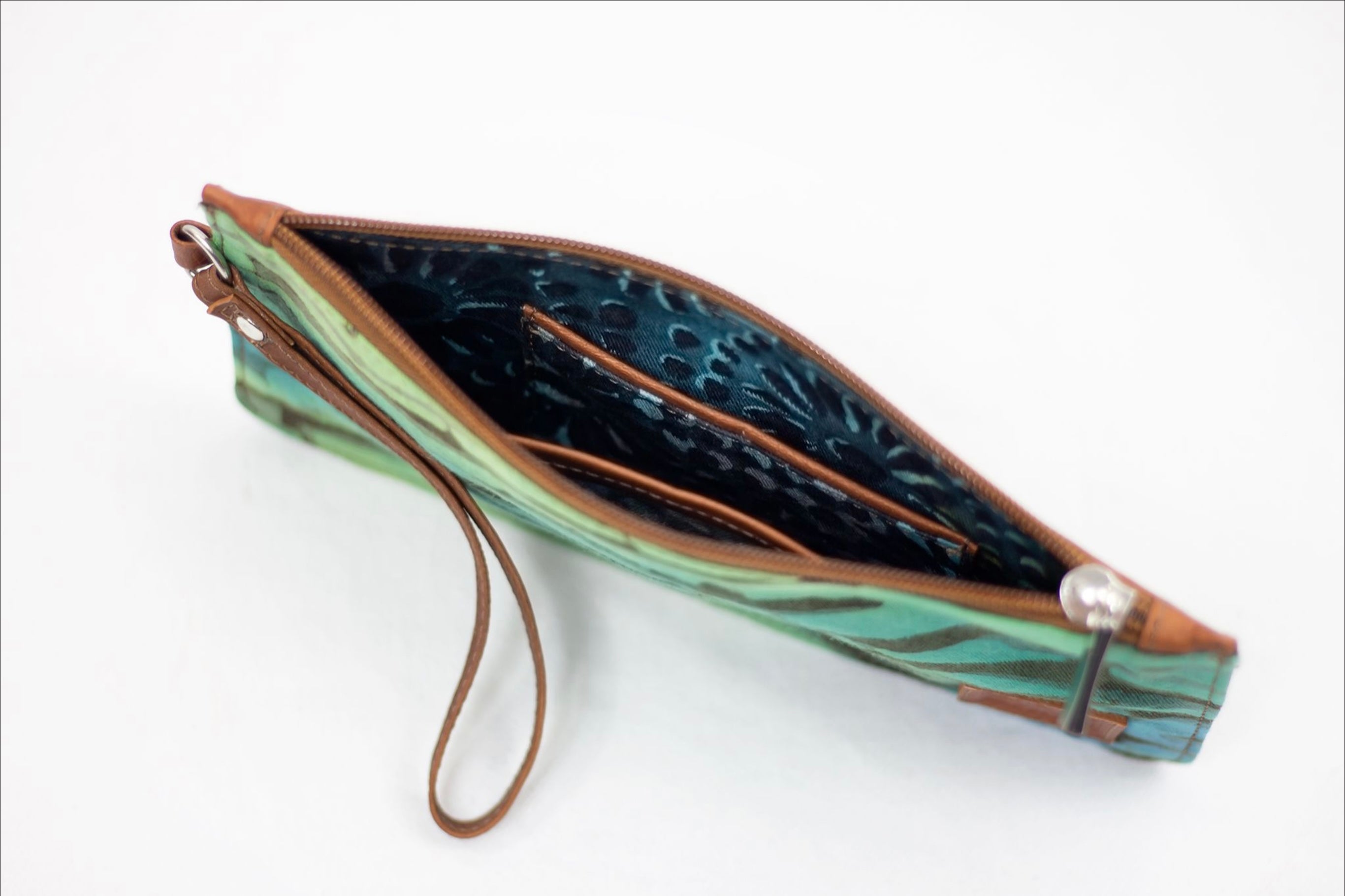 * Hand painted, leather trimmed clutch purse with the green and blue “Boo Verdi Blue” pattern. It has a blue floral lining.