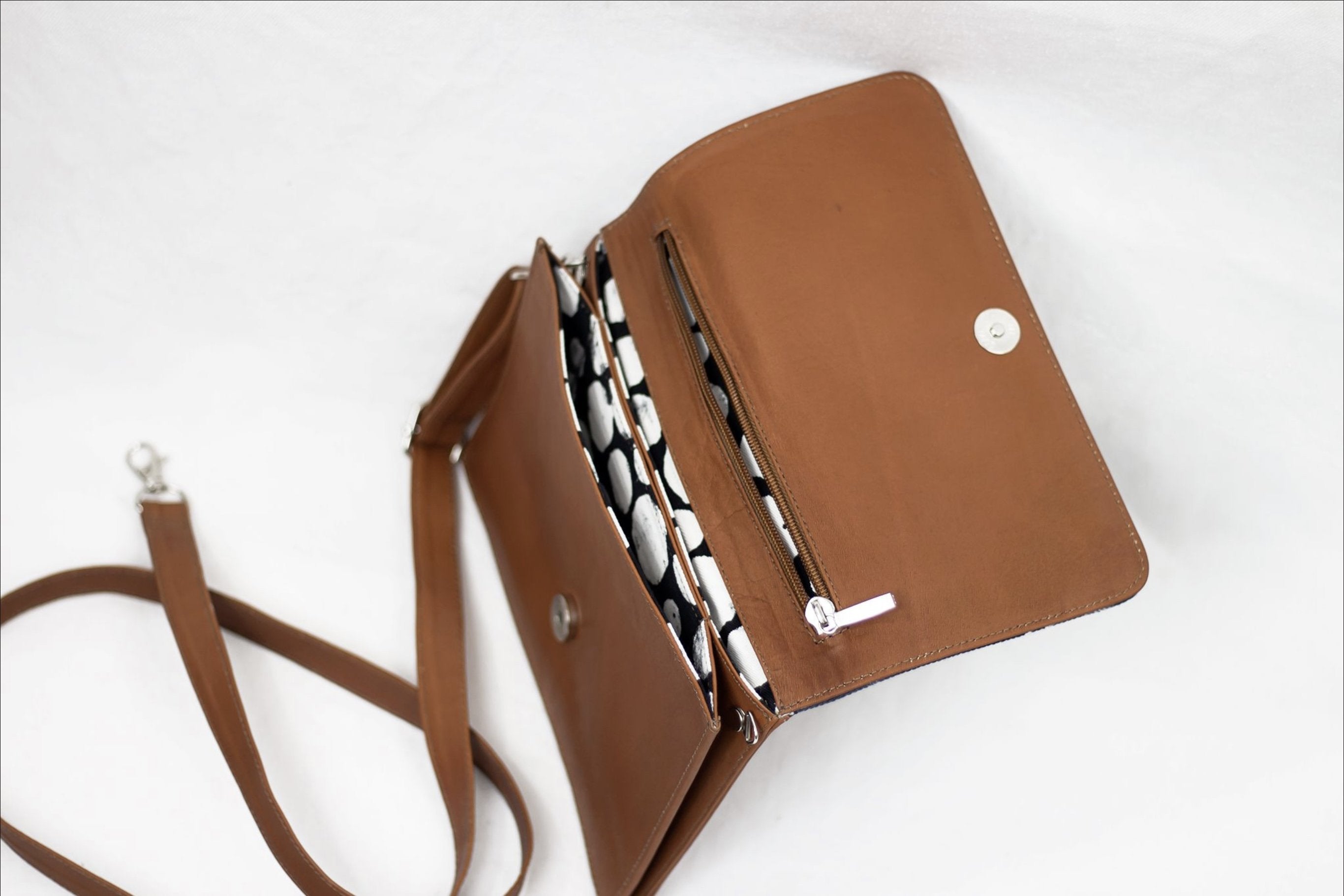 * Hand painted, leather trimmed cross body tote with the black and white “hula nights” pattern. It has a white polka dot lining.