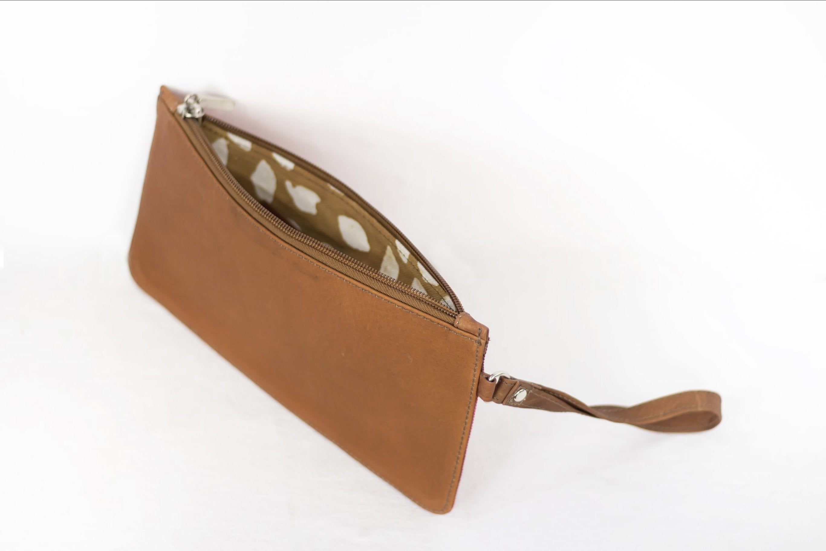 Hand painted, leather trimmed clutch purse with the red, orange and blue “fire palm” pattern. It has solid brown leather back.